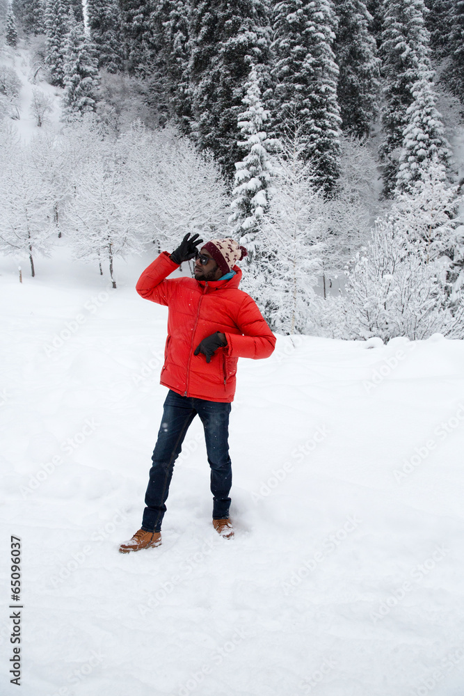 African American Cheerful black man in ski suit in snowy winter