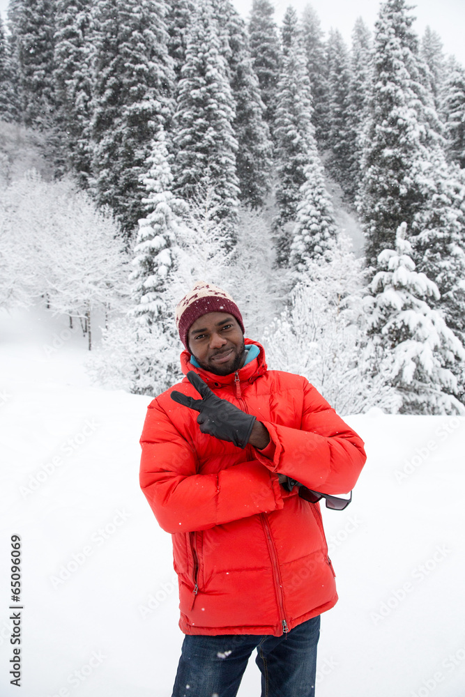 African American Cheerful black man in ski suit in snowy winter