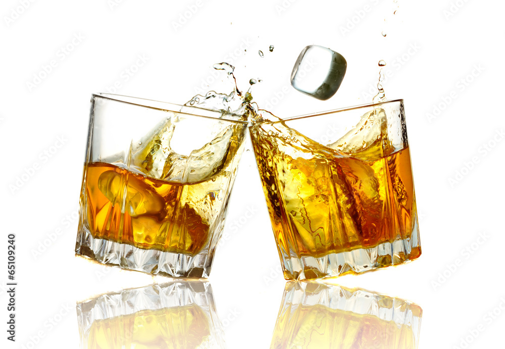 Two whiskey glasses clinking together, isolated
