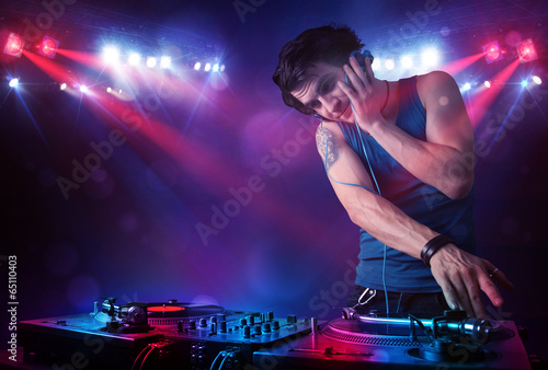 Teenager dj mixing records in front of a crowd on stage