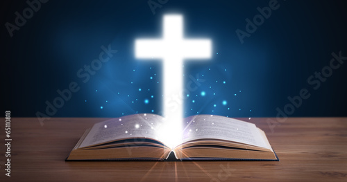 Fotografia Open holy bible with glowing cross in the middle