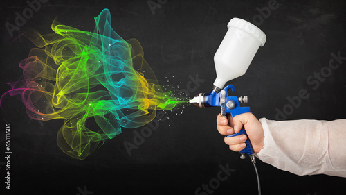 Painter working with airbrush and paints colorful paint photo