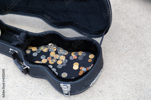 Coins in a guitar case in a street photo