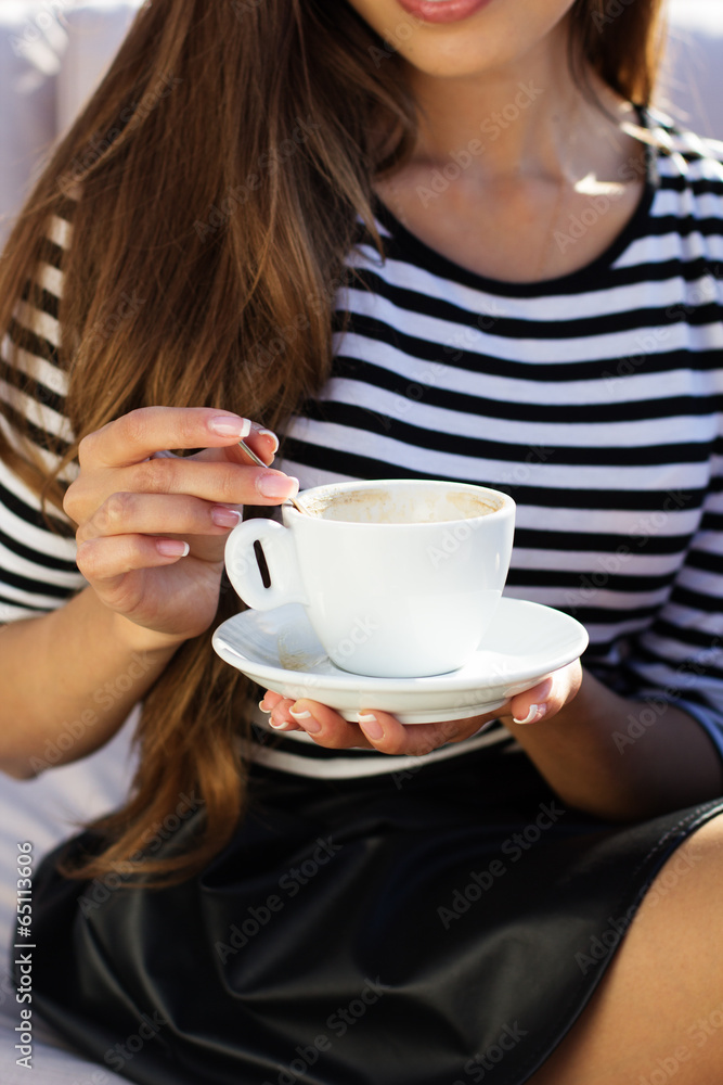 Young woman drinking coffee in a cafe outdoors Young woman drinking coffee in a cafe outdoors