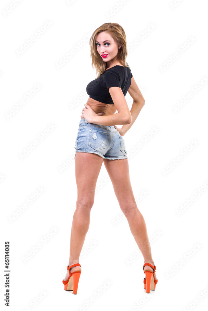 Pretty woman posing in sexy jeans shorts. Isolated on white Pretty woman posing in sexy jeans shorts. Isolated on white
