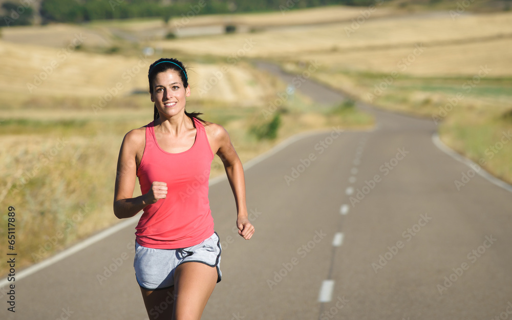 Sporty woman running in country road