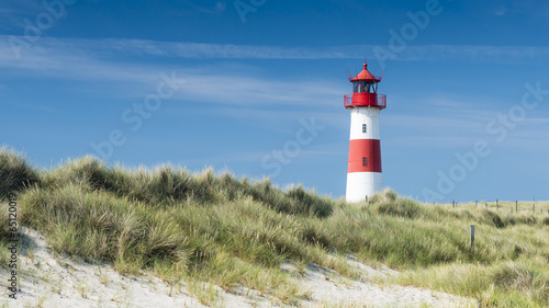 Red - white lightouse on wide dune on amazing German island Sylt. Horizontal.
