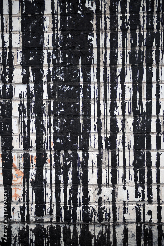 Obraz premium A white brick wall with streaks of bitumen.
