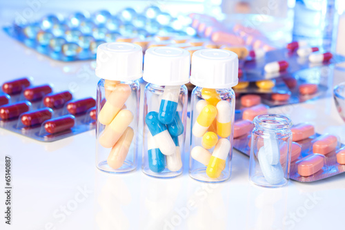 Colorful medical capsules in bottle, on white background.