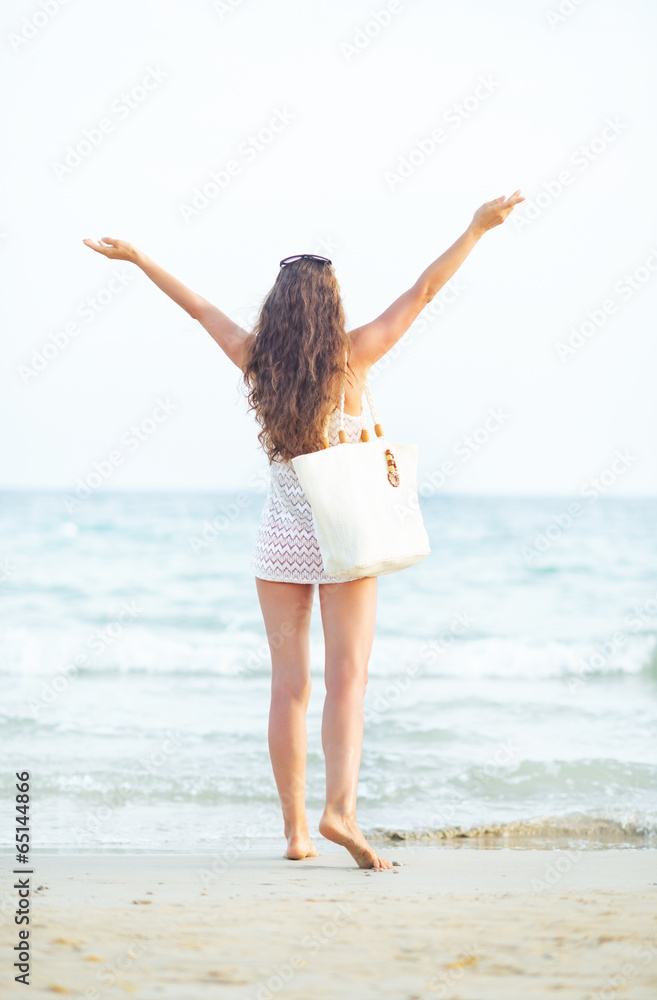 Young woman on beach in the evening rejoicing Young woman on beach in the evening rejoicing