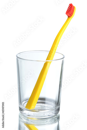 Toothbrush in glass on light grey background