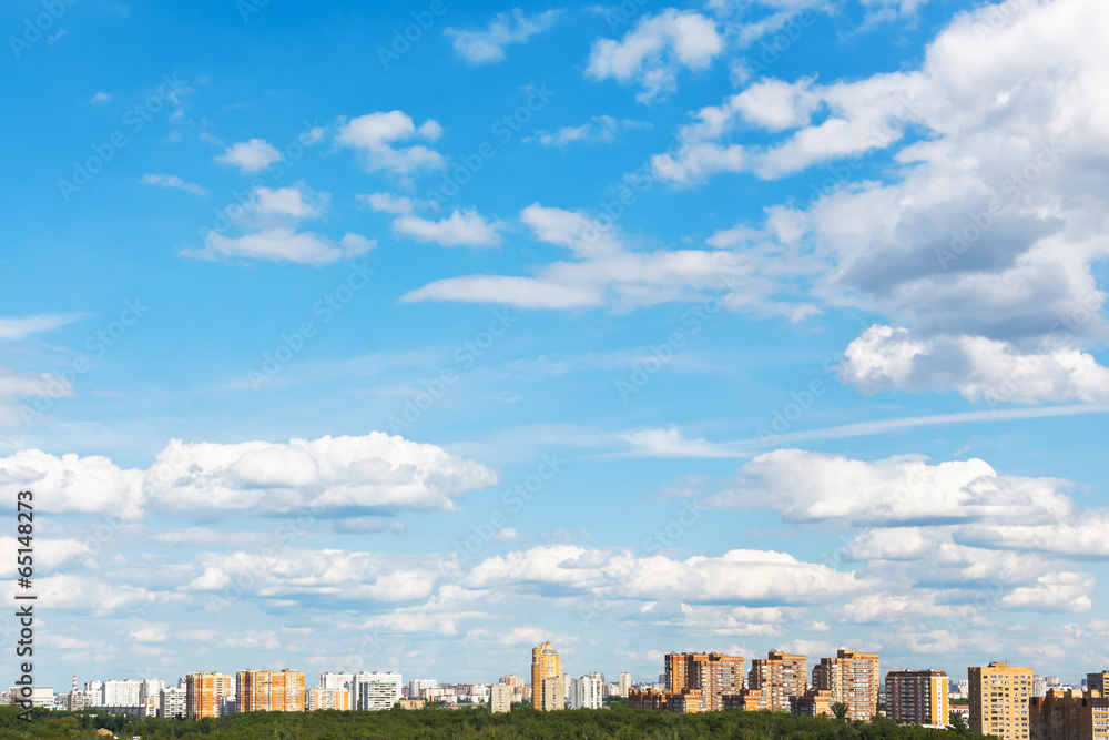 urban street under blue sky with fluffy clouds