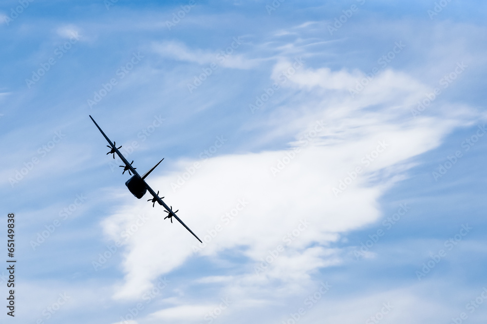 military cargo aircraft silhouette against a blue sky