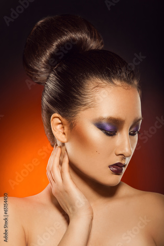 Gorgeous adult asuan woman looking away in studio