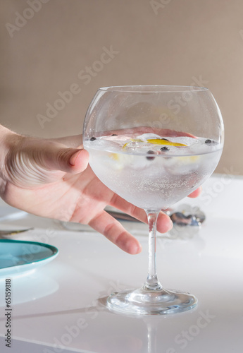 Hand picking gin tonic cocktail served on a glass