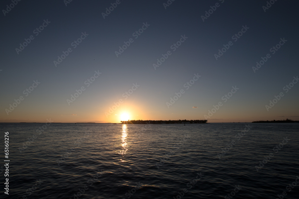 Fototapeta premium sunset over an island in the ocean