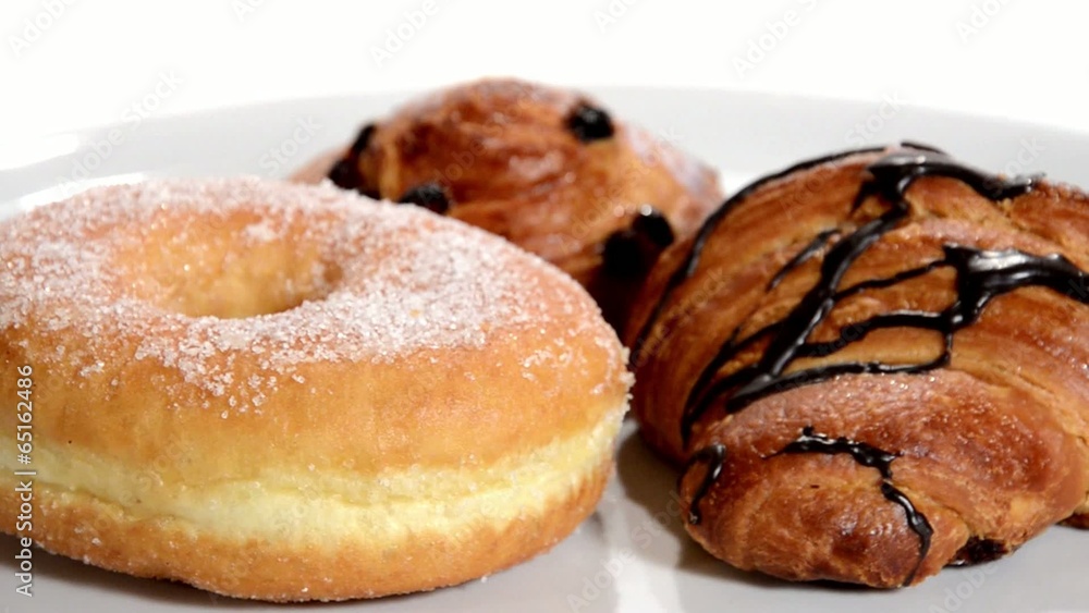 Croissant, doughnut and brioche with raisins rotating. Croissant, doughnut and brioche with raisins rotating.