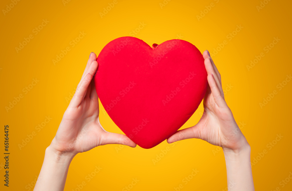 Hands holding shape heart on yellow background. Hands holding shape heart on yellow background.