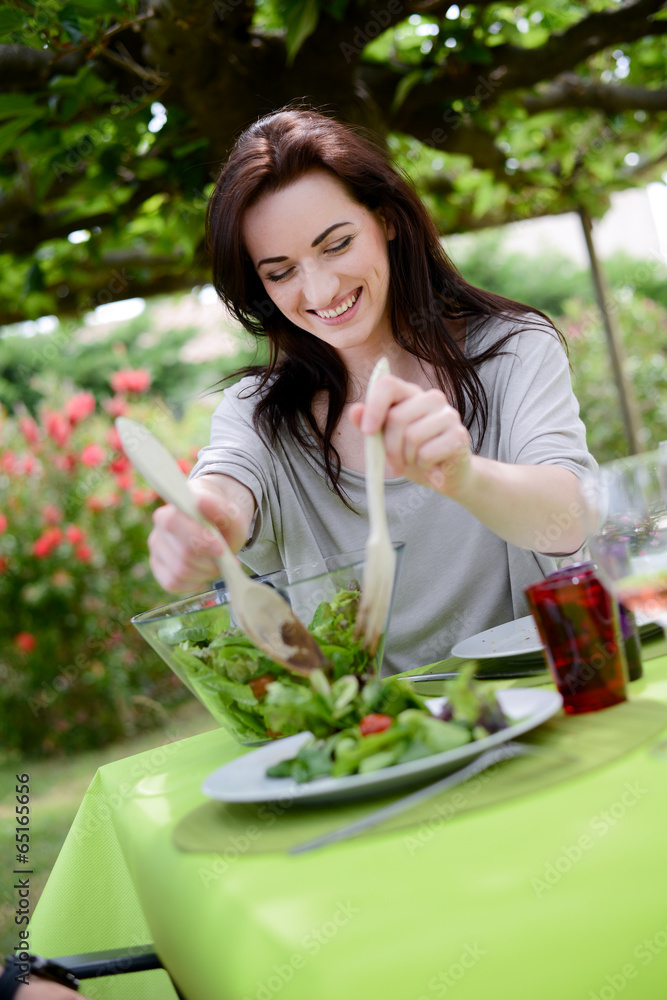 cheerful cute young woman eat salad at barbecue party cheerful cute young woman eat salad at barbecue party