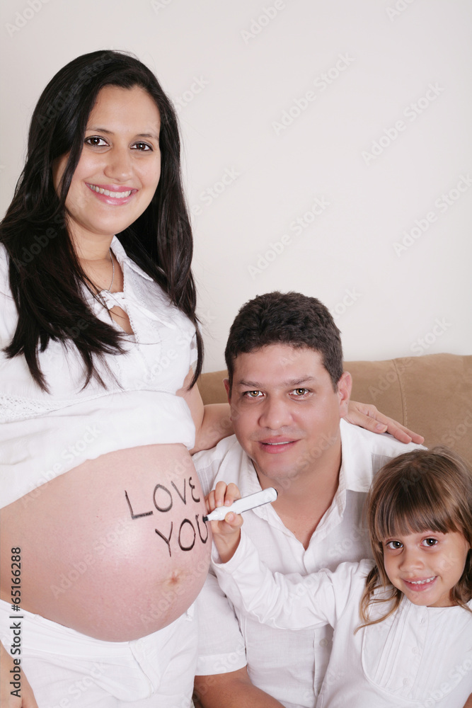 Family With Pregnant Mother Relaxing On Sofa Together with the w Family With Pregnant Mother Relaxing On Sofa Together with the w