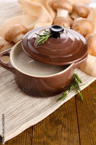 Mushroom soup in pot  on wooden background