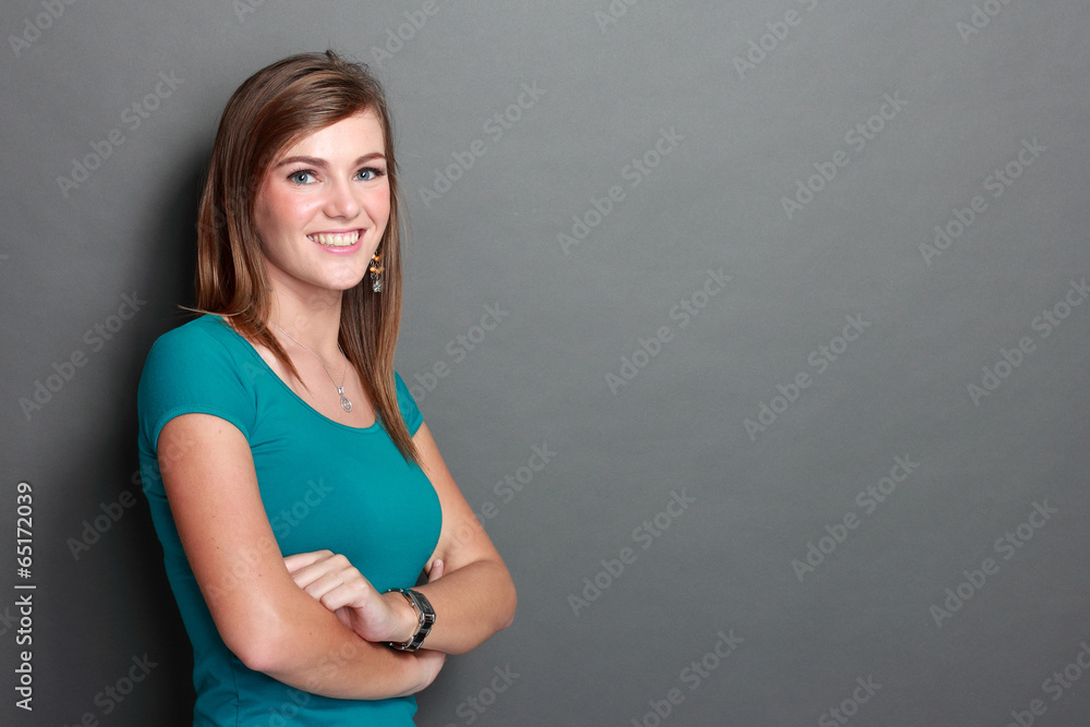 Beautiful young woman standing with arms crossed Beautiful young woman standing with arms crossed