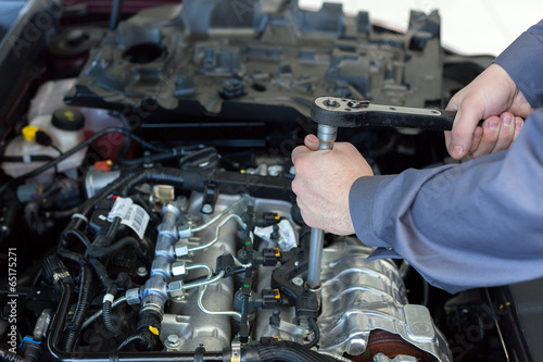 automotive mechanic tightening using a torque wrench