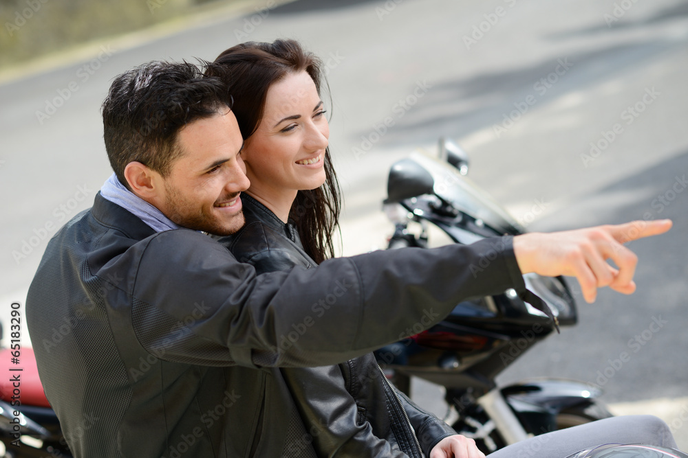happy young lovers couple riding a motorbike on a vacation trip happy young lovers couple riding a motorbike on a vacation trip