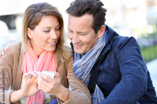 Couple in town using smartphone