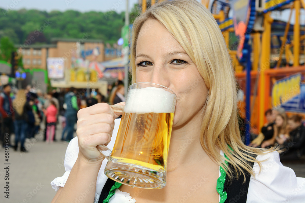 Frau im Dirndl auf Oktoberfest trinkt Bier Frau im Dirndl auf Oktoberfest trinkt Bier