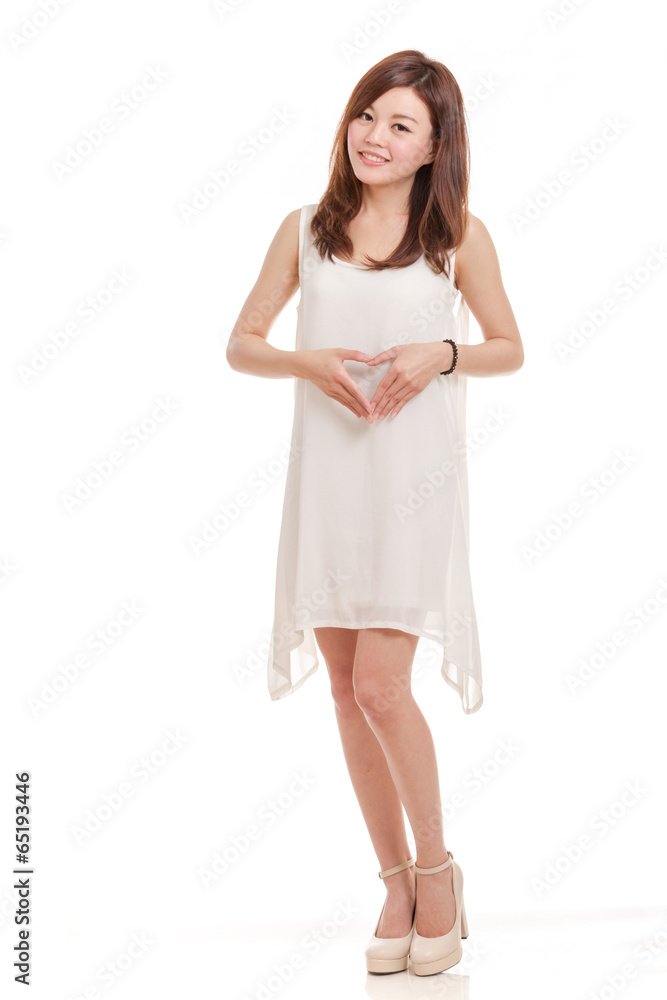Malaysian woman in white dress holding hands in shape of a heart Malaysian woman in white dress holding hands in shape of a heart