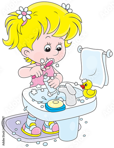 Little girl cleaning teeth in a bathroom