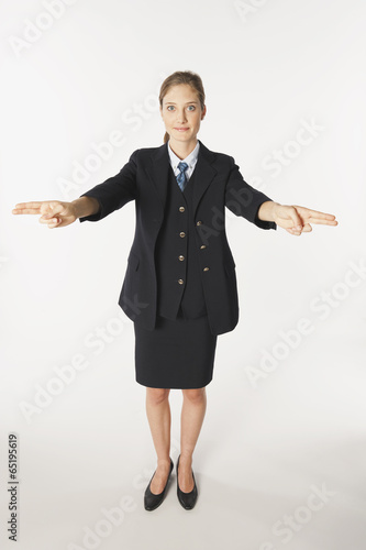 Junge Stewardess mit Pistole Zeichen gegen weißen Hintergrund,Lächeln,portrait