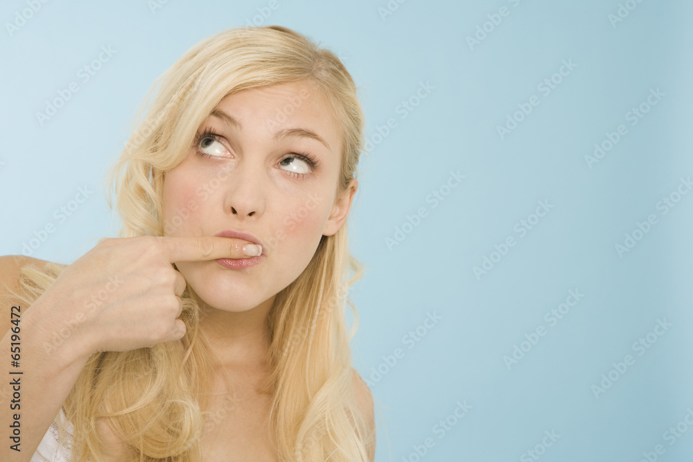 Junge Frau mit Finger auf den Mund,Portrait Junge Frau mit Finger auf den Mund,Portrait