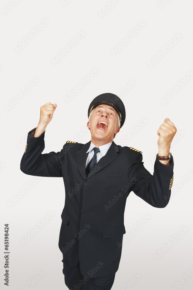 Ältere Flugkapitän gestikulierend vor weißem Hintergrund,lachen