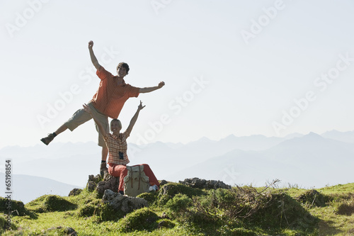 Junges Paar auf dem Berggipfel , die Arme , lächelnd .