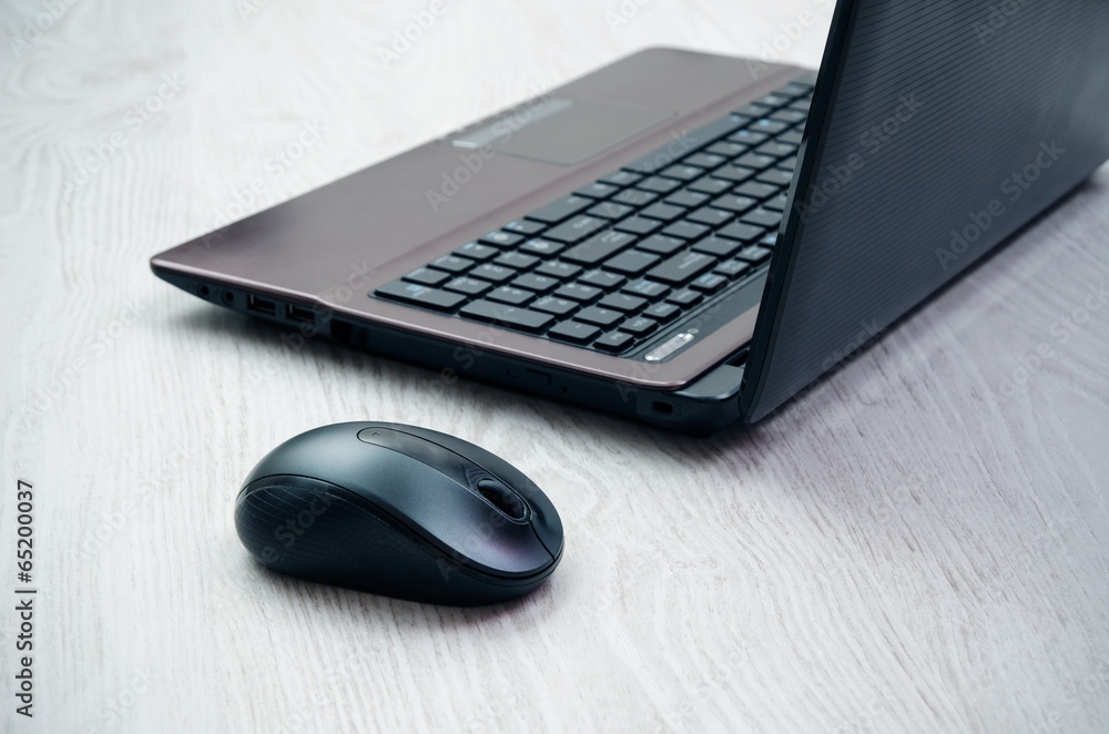 Modern laptop and mouse on light wooden desk Modern laptop and mouse on light wooden desk