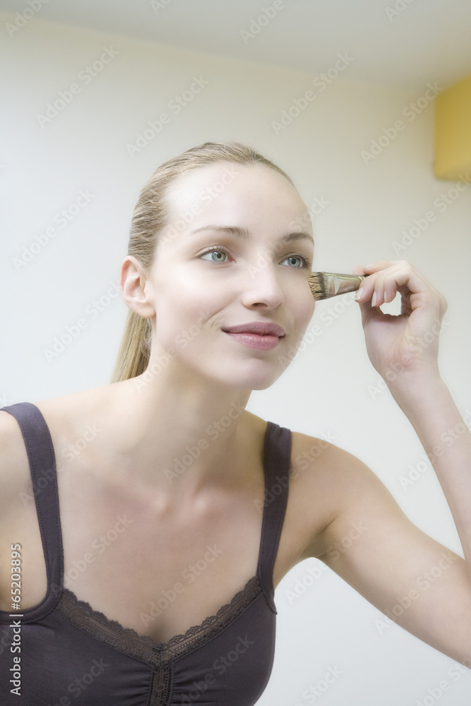 Fototapeta premium Junge Frau mit Make-up- Pinsel,Portrait