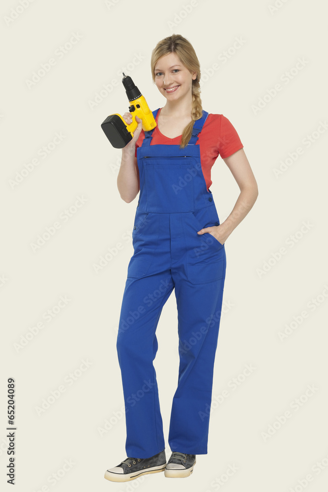 Junge Frau mit Bohrmaschine,Lächeln,Portrait Junge Frau mit Bohrmaschine,Lächeln,Portrait