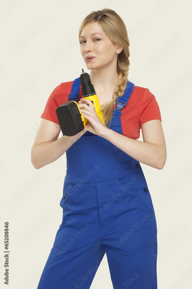 Junge Frau mit Bohrmaschine,Lächeln,Portrait Junge Frau mit Bohrmaschine,Lächeln,Portrait