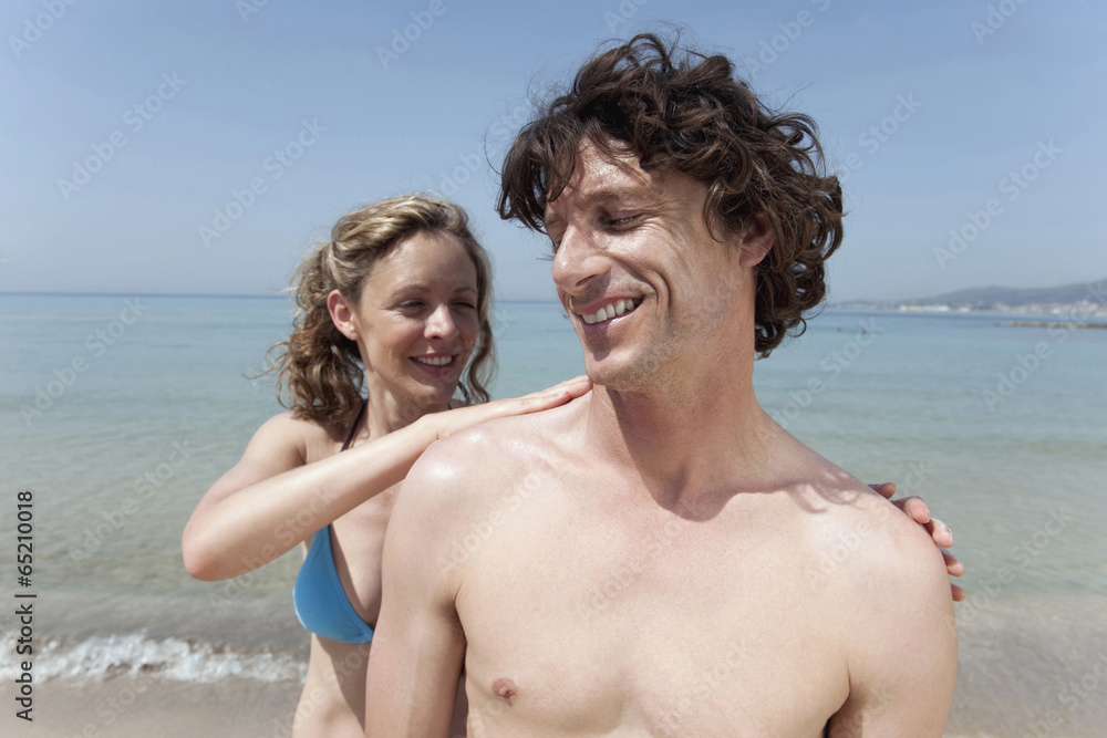 Spanien,Mallorca,Frau Anwendung Sonnencreme auf Schulter des Mannes Spanien,Mallorca,Frau Anwendung Sonnencreme auf Schulter des Mannes