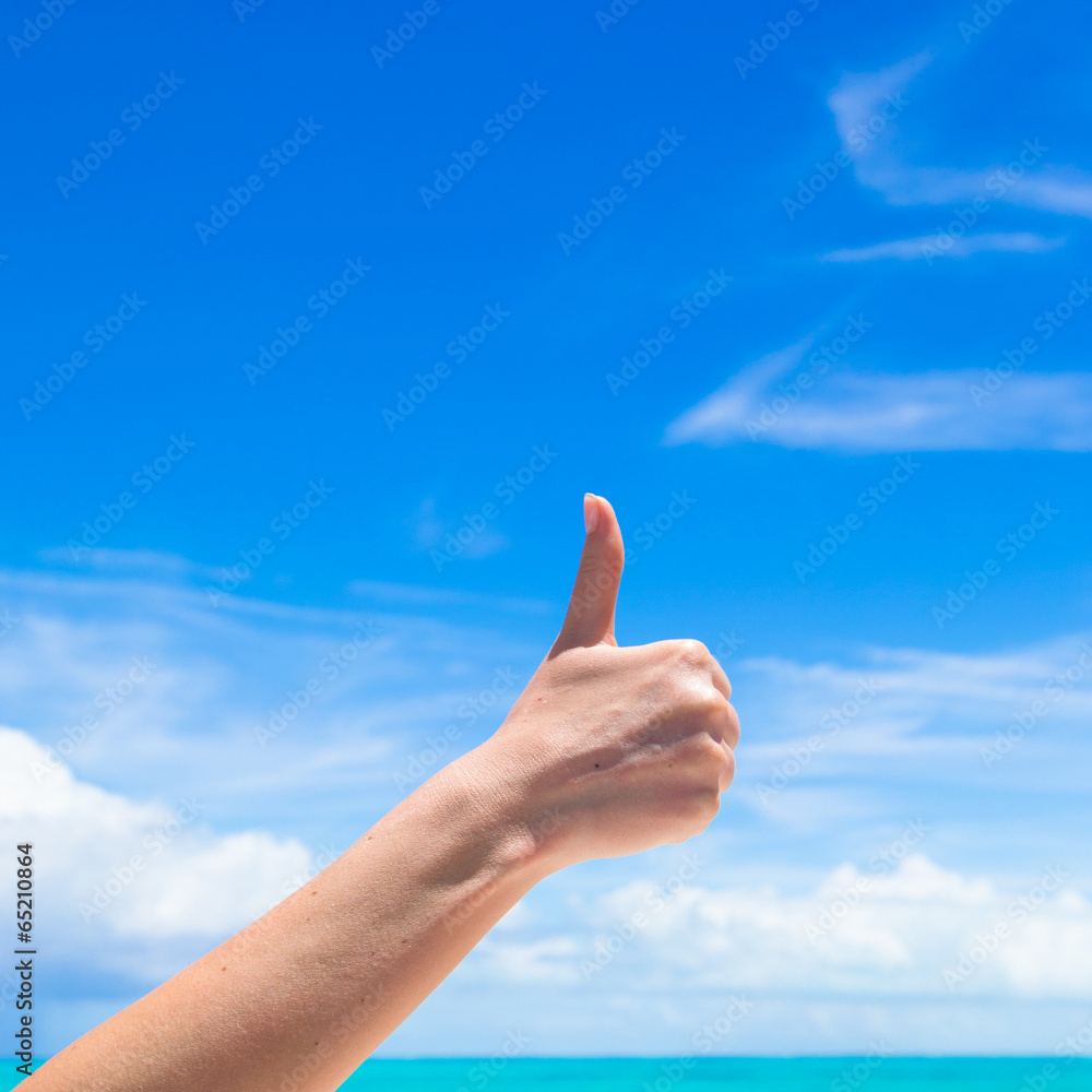 Closeup thumbs up on the beach background blue sky Closeup thumbs up on the beach background blue sky