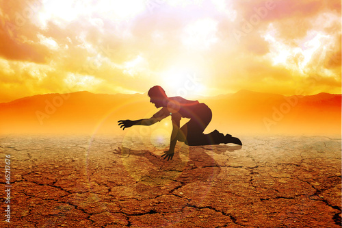 Silhouette of a man crawling on arid land