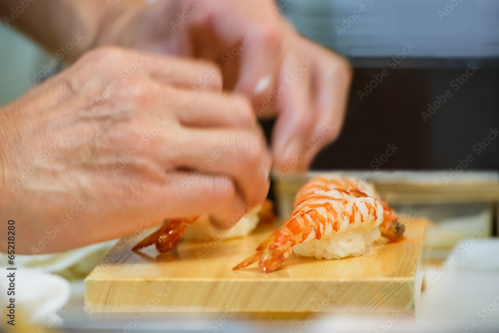 Hands of a Japanese Chef make a bowl of Sushi