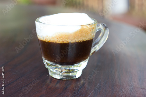 Hot  espresso with milk and foam in cup.