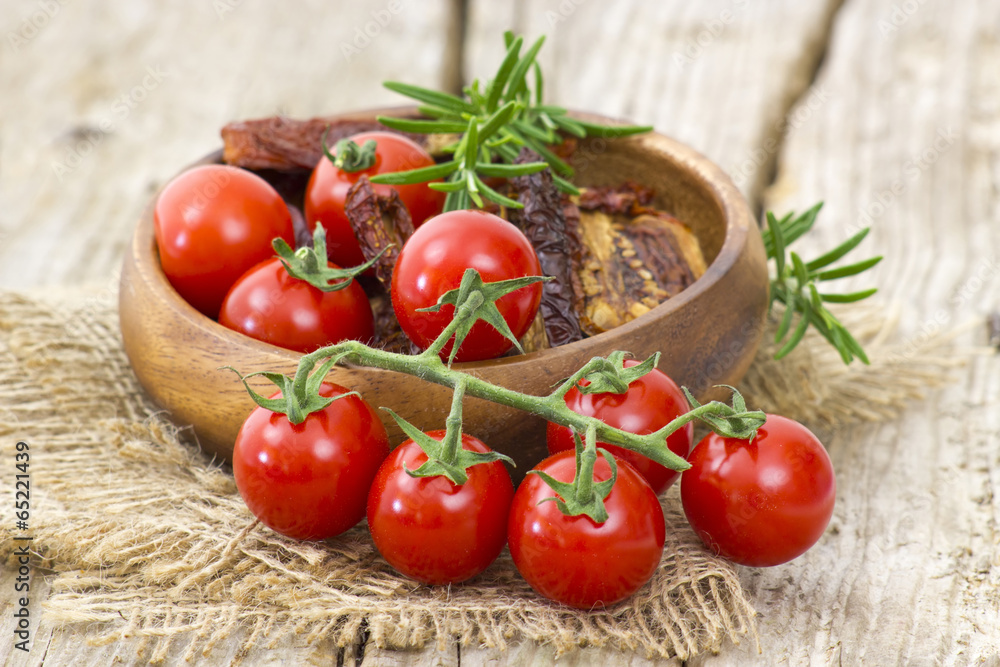 fresh and dried tomatoes on wooden background