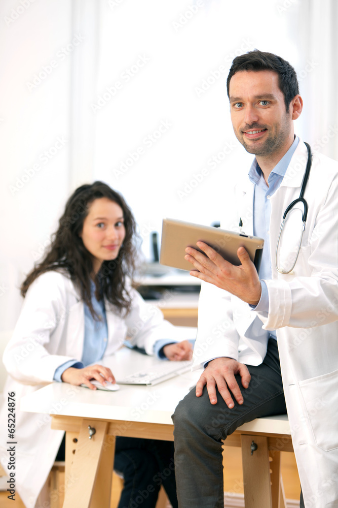 Fototapeta premium Portrait of a doctor using tablet and a nurse
