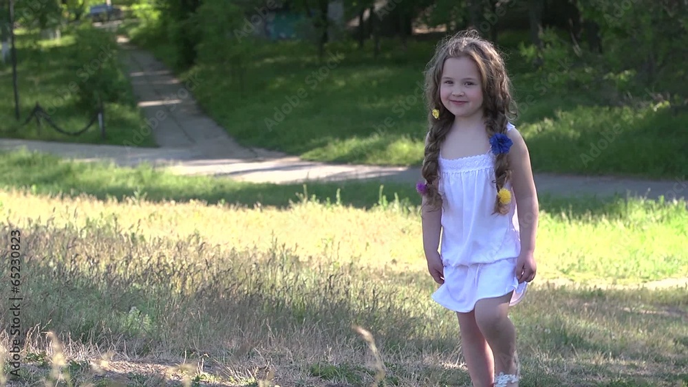 Beautiful little girl climbing the hill in the park Beautiful little girl climbing the hill in the park