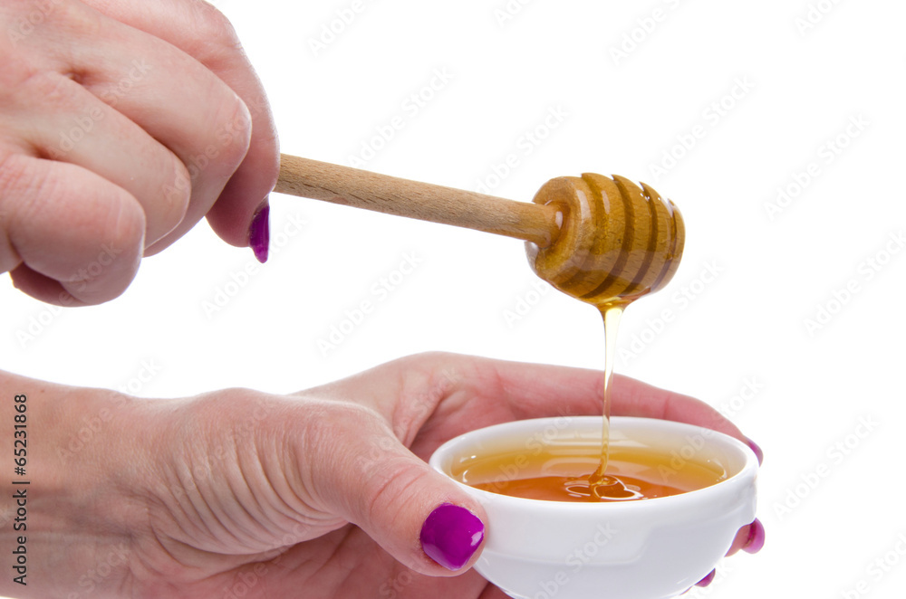 Woman's hand holding a honey dipper Woman's hand holding a honey dipper