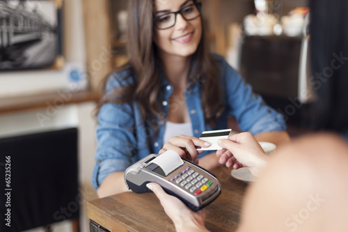 Smiling woman paying for coffee by credit card photo